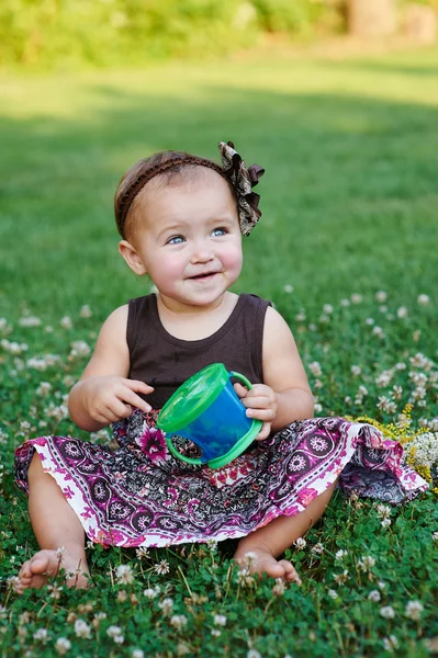 Menina feliz jogando no prado de verão na grama — Fotografia de Stock