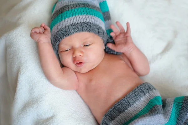 Mały chłopiec dziecko w czapka leżąc na łóżku — Zdjęcie stockowe