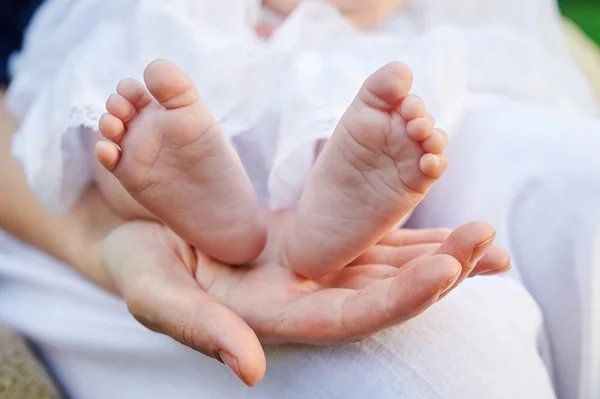 Mother hand holding small baby feet — Stock Photo, Image