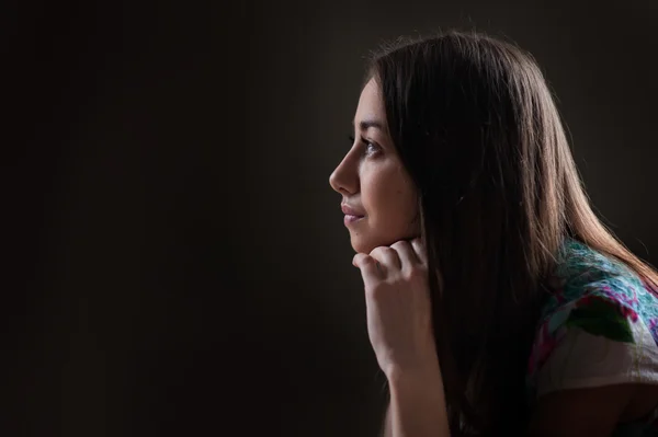 Belle femme regardant au loin sur un fond sombre — Photo