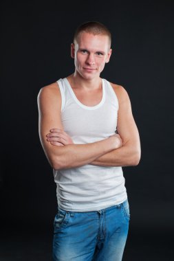 Karanlık grunge duvar ile beyaz boş t-shirt giyen yakışıklı adam