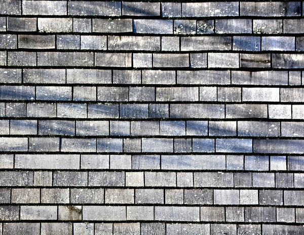 A background of gray weathered wood shingles outdoors