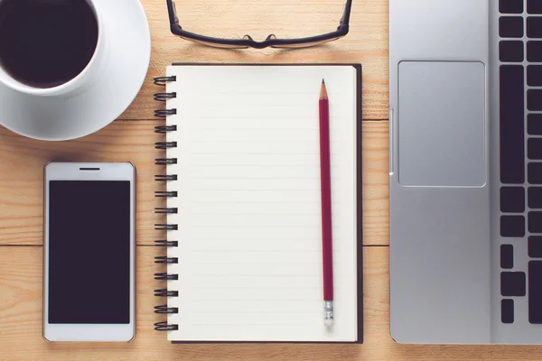 Notepad, smartphone, pen and cup of coffee on wood table - Work — Stock Photo, Image