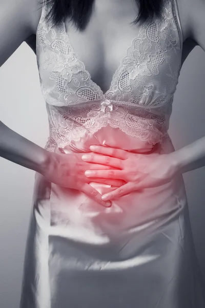 Žena s bolestivé břicho na šedém pozadí — Stock fotografie