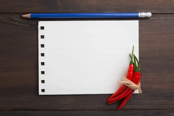 Rote Chilischoten auf dem alten Blatt Papier — Stockfoto