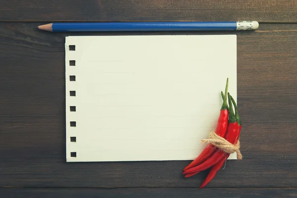 Rote Chilischoten auf dem alten Blatt Papier — Stockfoto