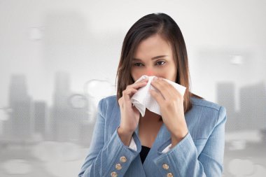 Businesswoman nose burning sensation because of the toxic smoke and particulate matter in the air. Woman with allergy, holding a tissue on his nose. PM2.5 clipart