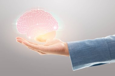 Kadın doktor gri arka planda beyin çizimi tutuyor. Ruh sağlığı koruma ve bakımı