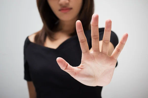 Jonge vrouw toont haar ontkenning met NEE op haar hand — Stockfoto