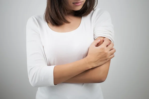 Mujer arañándose el brazo. — Foto de Stock