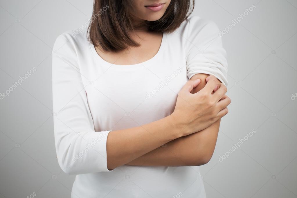 Woman scratching her arm.