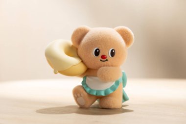 Bangkok\ Tayland - 24 Aralık 2025: Kocaman bir donut taşıyan sevimli bir ButterBear oyuncağının arka ışıklandırılmış fotoğrafı. Ilık ışık, neşeli ve büyüleyici kavramlar için uygun yumuşak, rahat bir ortam yaratır..