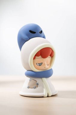 EMOR sanat oyuncağı başı üzerinde uysal bir ruhla battaniyeye sarılı bir çocuğu gösteriyor, masumiyet, fantezi ve duygusal hikaye anlatımını koleksiyonluk oyuncaklarla ifade ediyor..