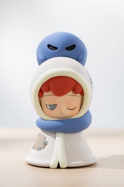 EMOR sanat oyuncağı başı üzerinde uysal bir ruhla battaniyeye sarılı bir çocuğu gösteriyor, masumiyet, fantezi ve duygusal hikaye anlatımını koleksiyonluk oyuncaklarla ifade ediyor..