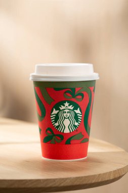 Starbucks 'ın sıcak kahvesi ahşap bir masada sunuluyor, kaliteli lezzet, sıcak atmosfer ve ikonik kahve alma tarzı sunuluyor..