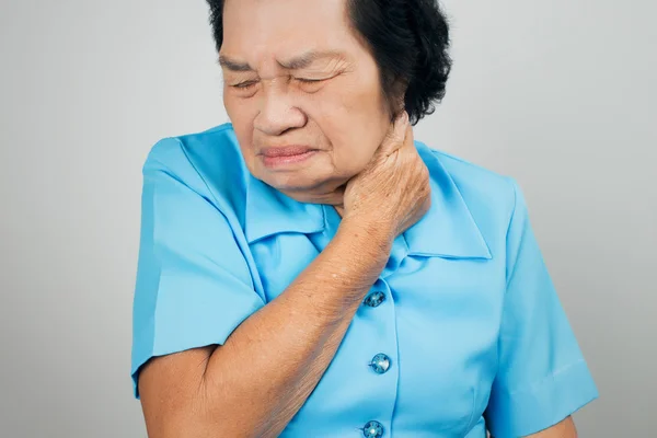 Donna anziana che soffre di dolore al collo su sfondo bianco — Foto Stock