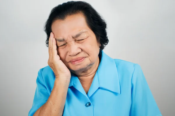 Mulher velha tem uma dor de cabeça — Fotografia de Stock
