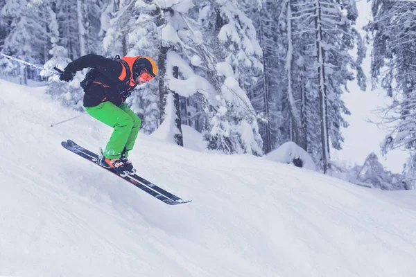 A person caught in mid ski jump in a forest covered in thick snow near Mayrhofen in Austria. The extreme weather made and surrounding fog boosted the adrenaline