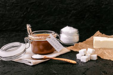 Pişirilmiş tuzlu karamel. Karamel için malzemeler. Kavanozda tuzlanmış karamel..