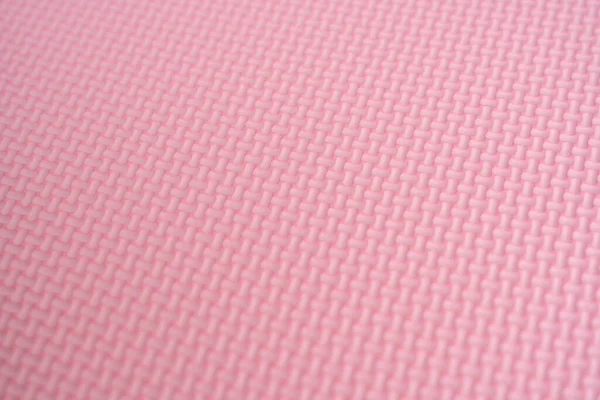 The surface of the pink foam rubber floor tiles. Selective focus