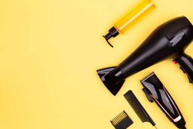 Saç kurutma, tarak, sprey, sarı arka planda makas, yazı için yer, düz yatış