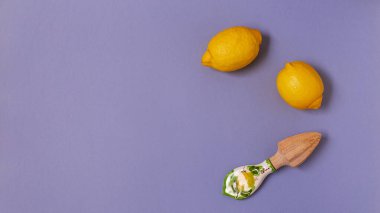 Sulu limonların üst görüntüsü ve mor arka planda güzel bir seramik sapı olan el yapımı ahşap sıkacağı.