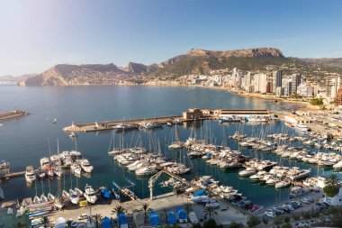 İspanya 'nın Akdeniz kıyısındaki Calpe tatil beldesinde deniz, yat, göl, gökdelenler ve dağ sıraları
