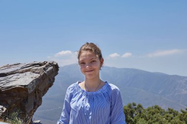 Dağ manzarasının tepesinde boş duran, gökyüzünde bulutlar olan boş bir uçurum.