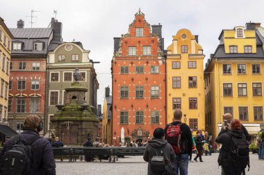 Stockholm, İsveç 24 Eylül 2017: Turistler Stockholm, İsveç 'in merkezindeki Old Town Gamla Stan' de Stortorget Meydanı 'ndaki renkli evlerin fotoğraflarını çekiyorlar