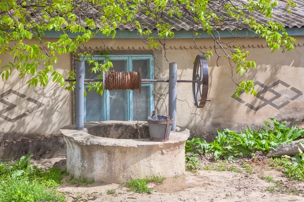 Rural water well near house — Stock Photo, Image