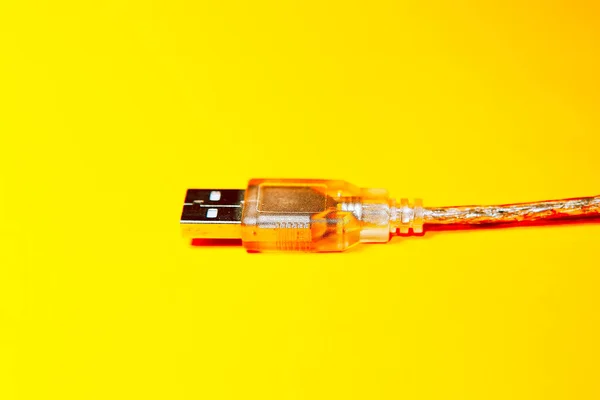 Transparent USB cable at yellow background