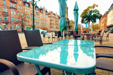 Yağmurdan sonra sokak terası. Kafe masasında şehir yansıması 