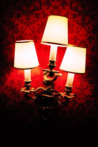 薄暗い光の中で壁にデラックスベルランプシェード ライトアップされた赤い壁のランプ — ストック写真