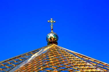 Altın çatılı çan kulesi ve üstünde haç 