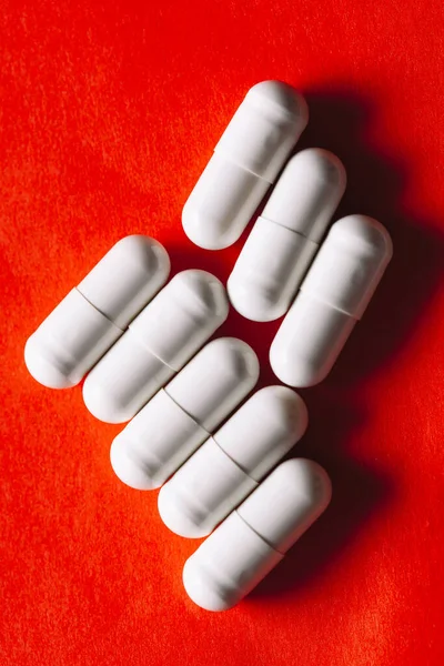 Pills in white capsules at red . Pills for the treatment of stomach diseases