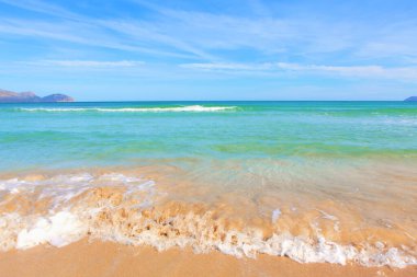 Mallorca 'nın Alcudia Körfezi. Su sıçratan dalgalı tropik plaj