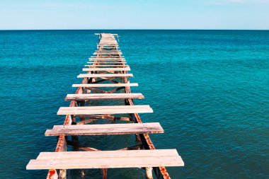 Kırık ahşap döşemeleri olan eski bir ranza. Kuş uçmaz kervan geçmez bir yer. Denize giden yol