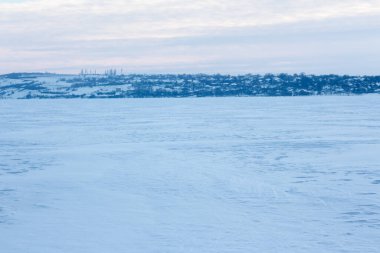 Donmuş gölün karlı tarlası. Kışın kırsal bir manzara 