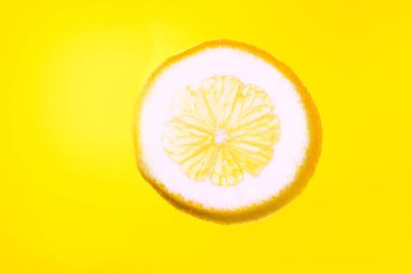Sarı arka planda limon. Güneş ışığında dilimlenmiş limon