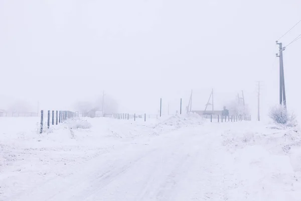 Hard road covered by snow . Winter rustic scenery