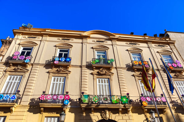 Spanish residential house with traditional decoration . Embroidered decorations on balconies