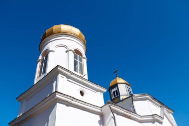 Mavi gökyüzüne karşı beyaz manastır. Altın kubbeli ibadet yeri