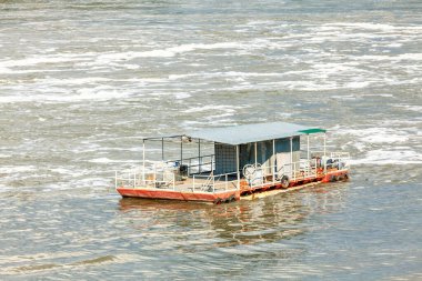 İnsanları nehirden geçirmek için yüzen küçük feribot.