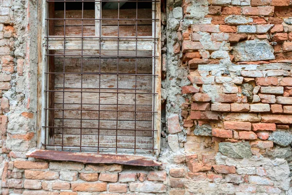 Ruined brick wall with old window . Details of ruined wall of abandoned house