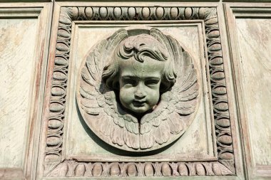 Yüzü duvar plaketinde. Kilise duvarında melek kafası var.