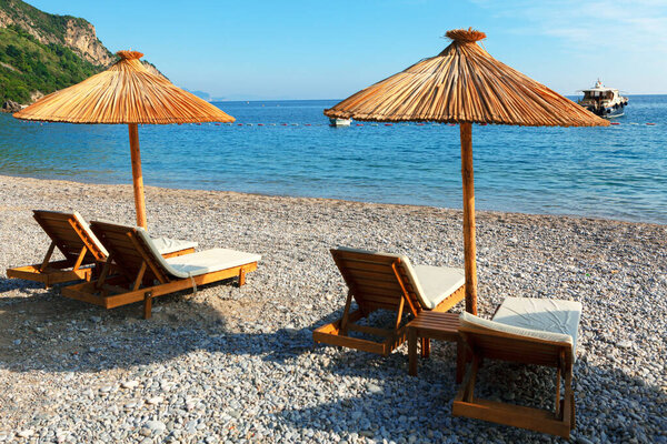 Lounge chairs on a beautiful tropical beach . Summer vacation on the island . Luxury Tourist Resort 