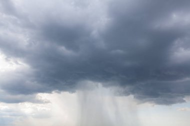 Cloudburst with a sudden heavy rainfall . Dark clouds with torrential rain