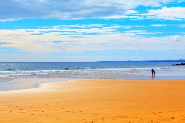 Sandy Atlantik Okyanusu Kıyısı. Bebekli genç anne kıyıda yürüyor. Yaz tatili littoral... 