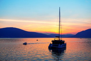 Alacakaranlıkta lüks bir yat. Körfezin üzerinde alacakaranlık. Milyoner yatı