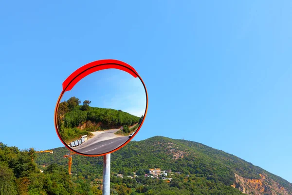 Outdoor Traffic Mirror with mountains on background . Curved Mirror.  Round Mirror For Blind Spots on the road